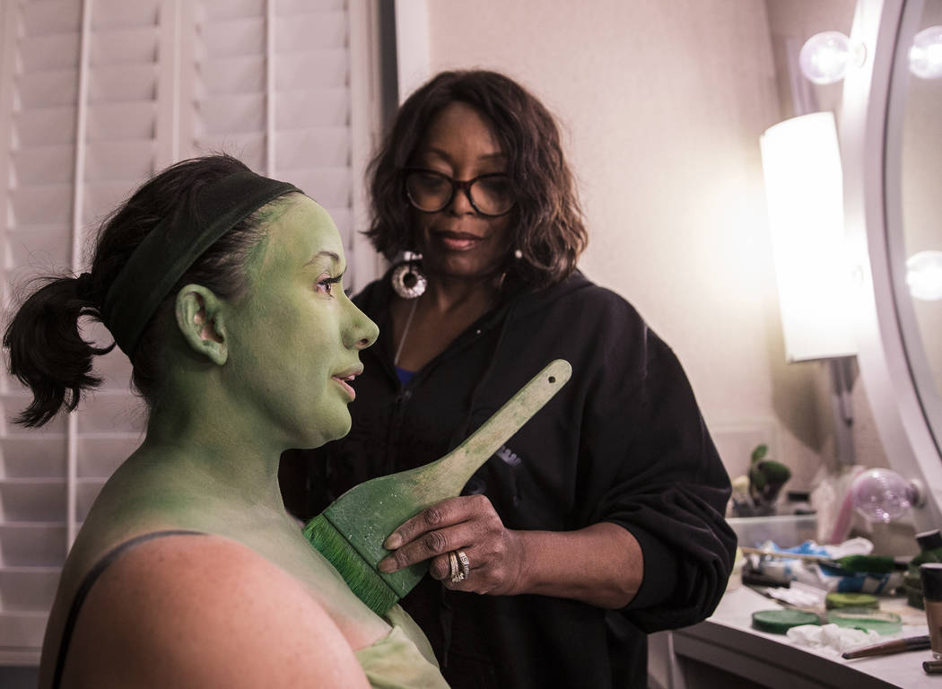 Mariand Torres, left, who plays Elphaba in "Wicked," gets her makeup done by makeup supervisor ...