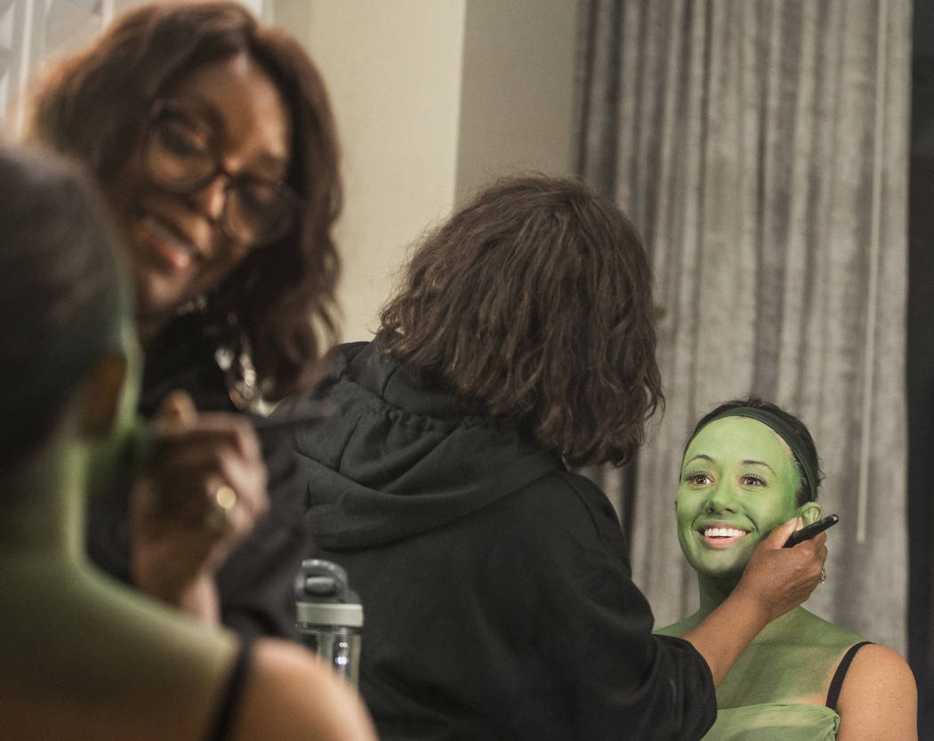 Mariand Torres, right, who plays Elphaba in "Wicked," gets her makeup done by makeup supervisor ...