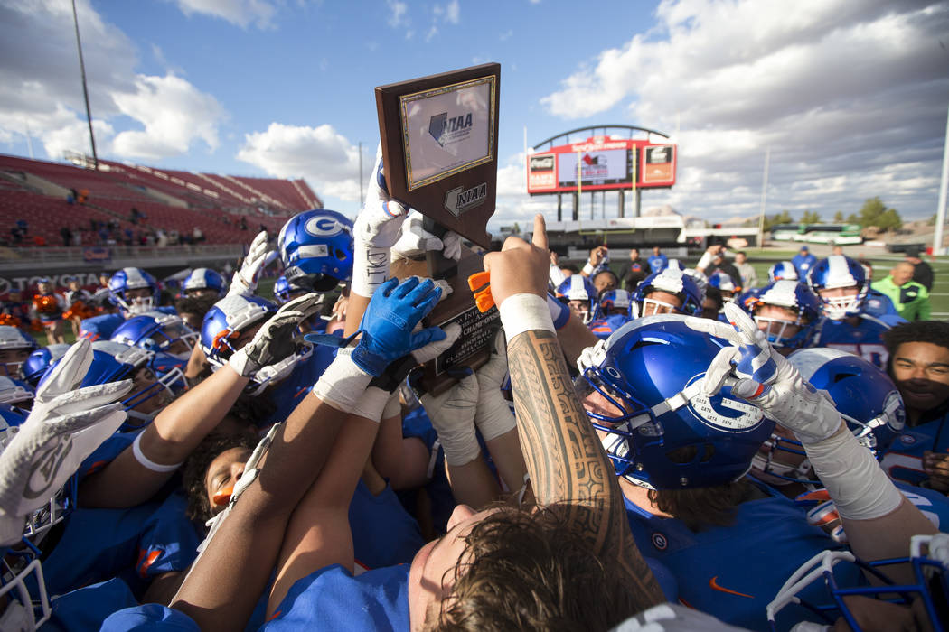 Bishop Gorman players celebrate with the trophy after defeating Reno's Bishop Manogue 69-26 in ...