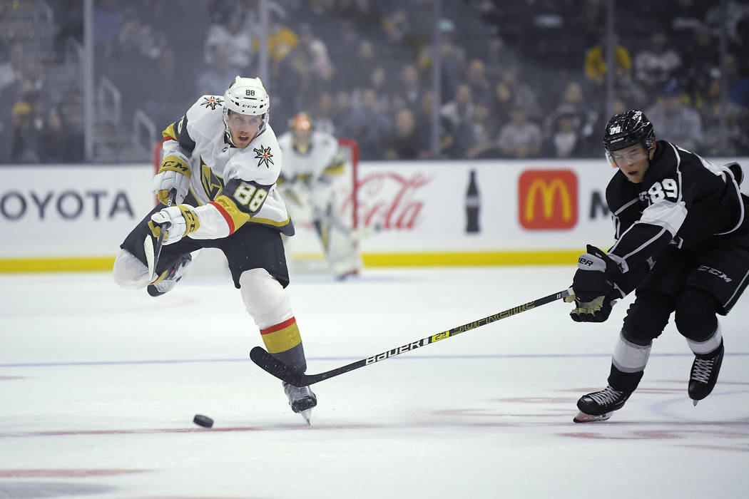 Vegas Golden Knights defenseman Nate Schmidt, left, passes the puck as Los Angeles Kings center ...