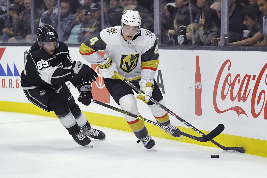 Vegas Golden Knights defenseman Jimmy Schuldt, right, moves the puck while under pressure from ...