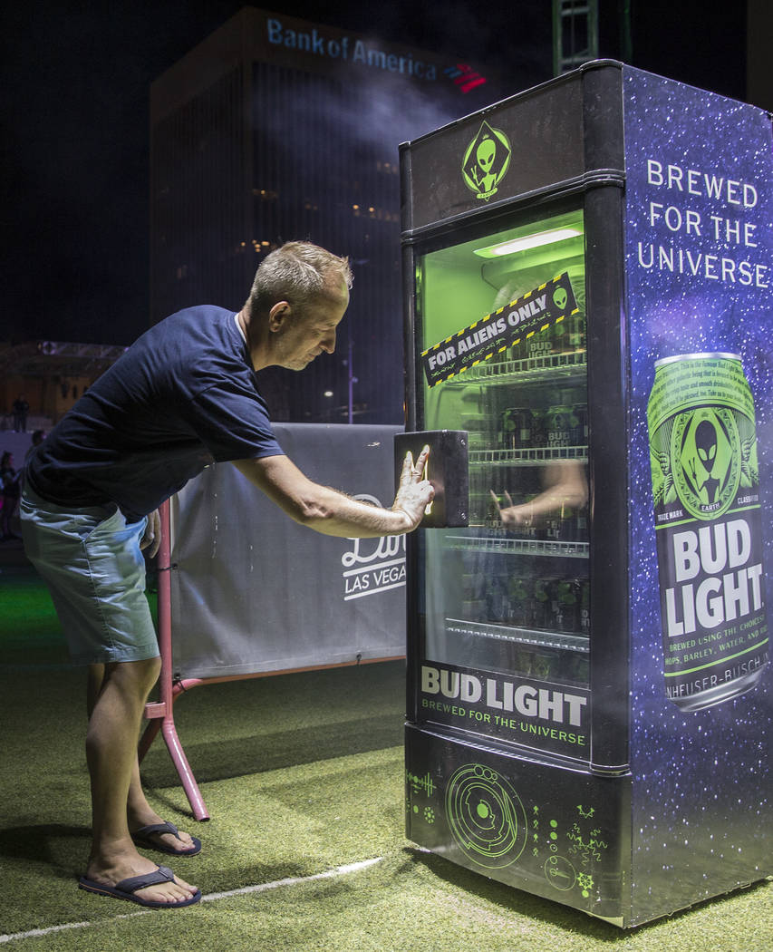 Sean Marcoux tries to unlock a case of special alien edition Bud Light during the Area 51 Celeb ...
