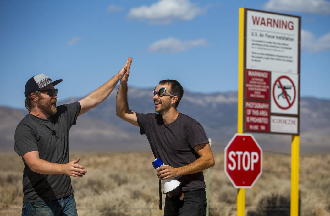 Devin Caldarone, left, and Mike Dye of Los Angeles celebrate their pretend crossing into Area 5 ...