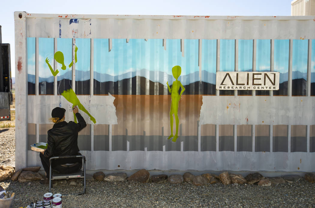 Artist Brandy Whisenant continues to paint a mural on the side of a container about the Area 51 ...