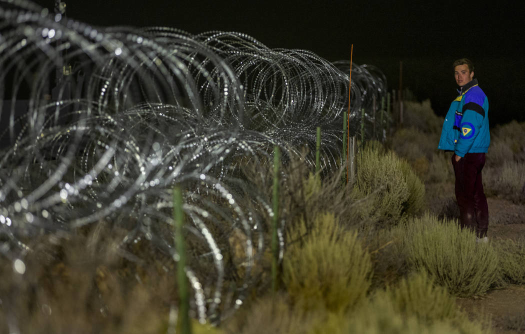 Michael Fortner of Cincinnati wanders along the fence line near the back gate of Area 51 in ho ...