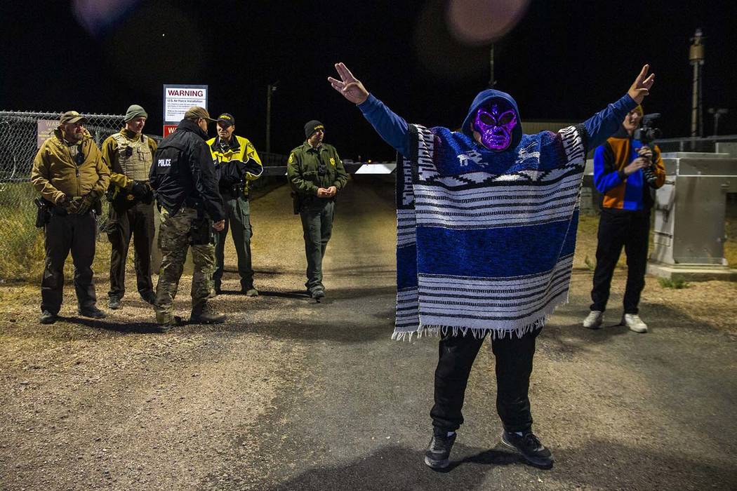 A masked individual arrives at the Area 51 back gate and stands before security personnel to pa ...
