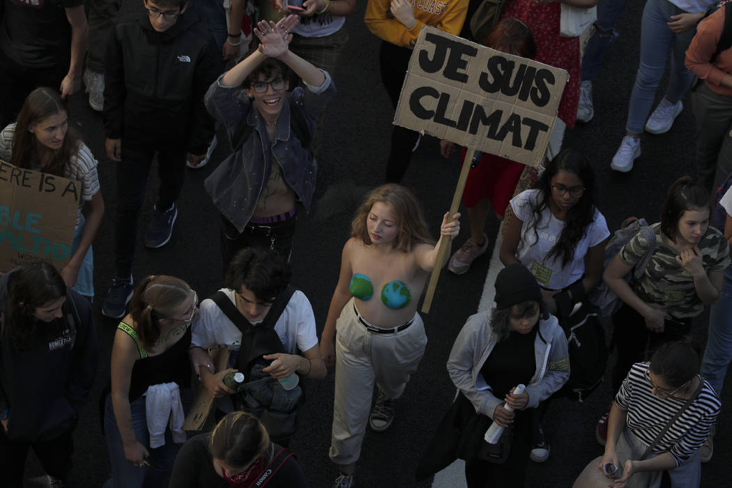 A woman holds a poster reading 'I am climate" during a climate demonstration Friday, Sept. ...