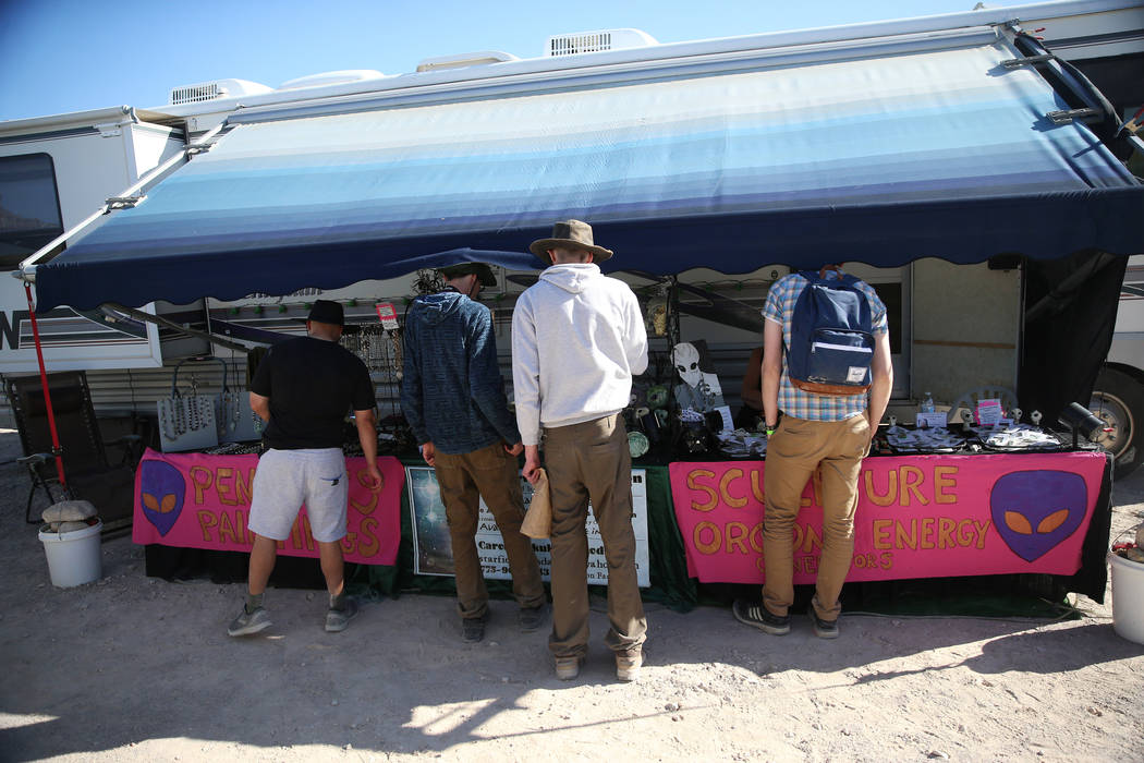 People browse a stand at the Alien Basecamp alien festival at the Alien Research Center in Hiko ...