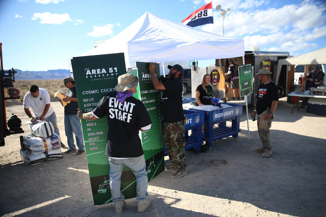 Staff members set up signs during the Alien Basecamp alien festival at the Alien Research Cente ...