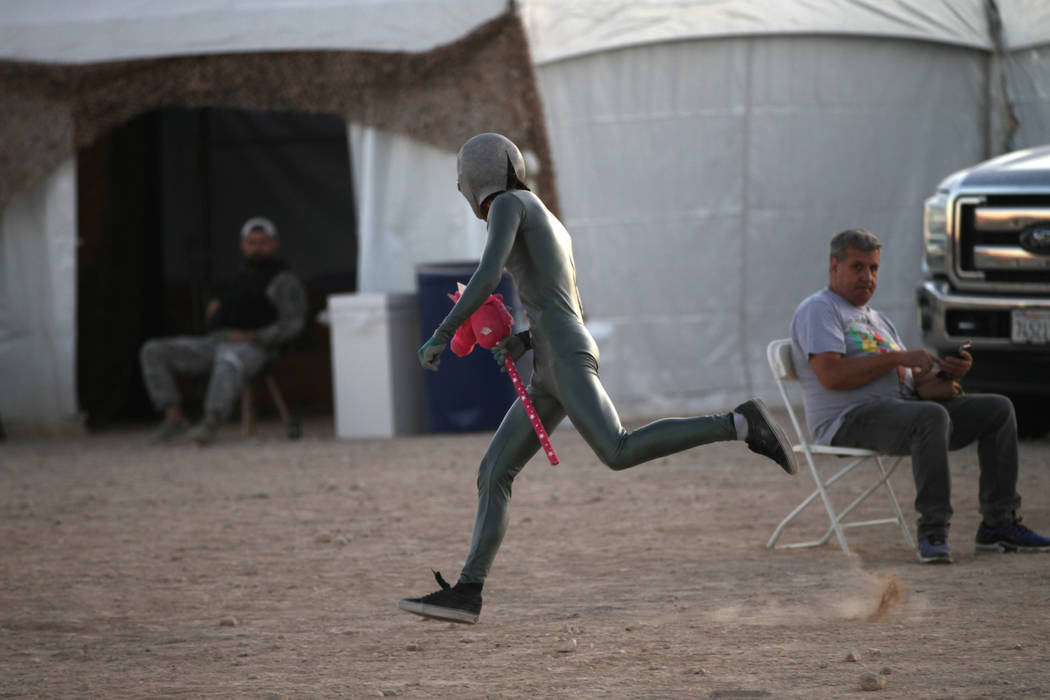 A person runs wearing an alien costume during the Alien Basecamp alien festival at the Alien Re ...
