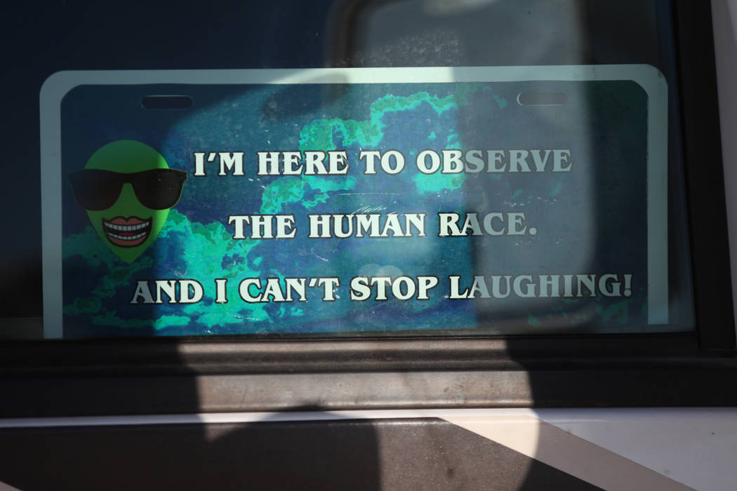 A sign inside a vehicle parked parked outside oft the Alien Basecamp alien festival at the Alie ...