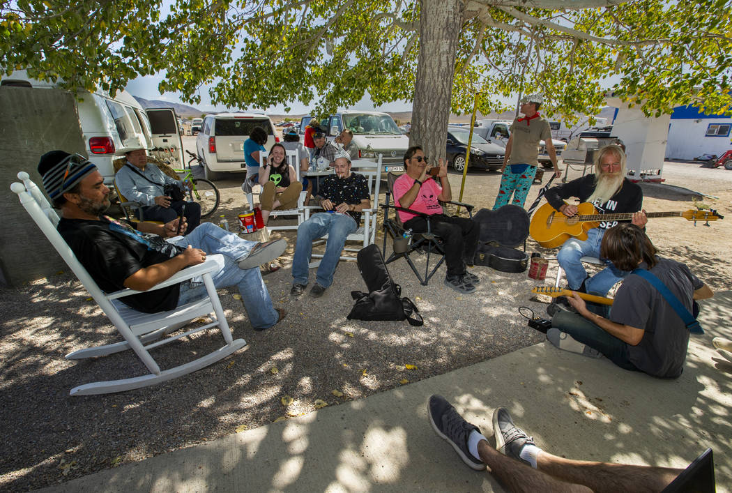 Festivalgoers relax and enjoy some music under the tree at the Little A'Le'Inn during the Alien ...