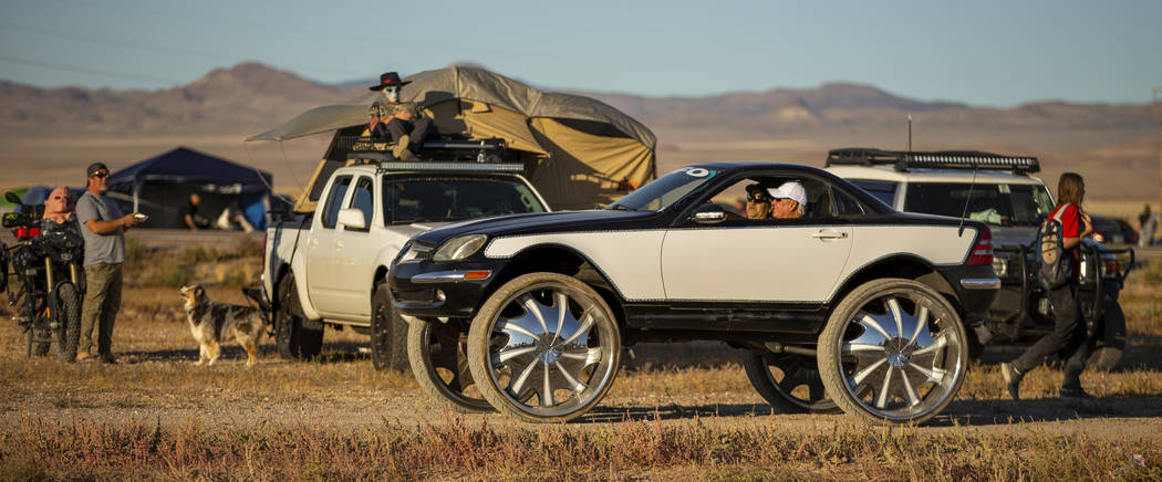 A custom vehicle cruises past festivalgoers parked on the frontage road during the Alienstock f ...