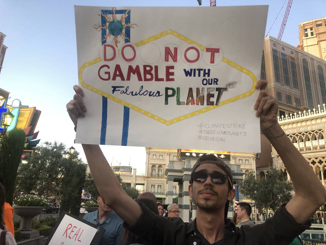 Israan Mendes, 24, holds a sign as more than 100 people protest Friday, Sept. 20, 2019, outside ...