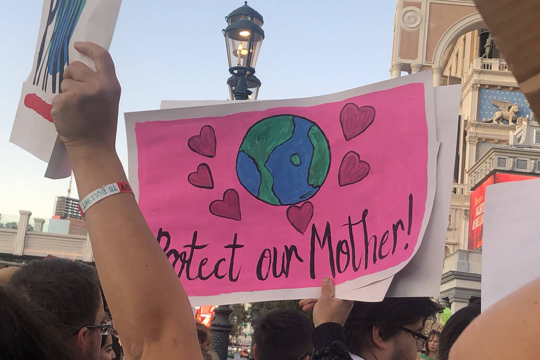 A protester’s sign reads “Protect our Mother” as more than 100 people protest Friday, Sep ...