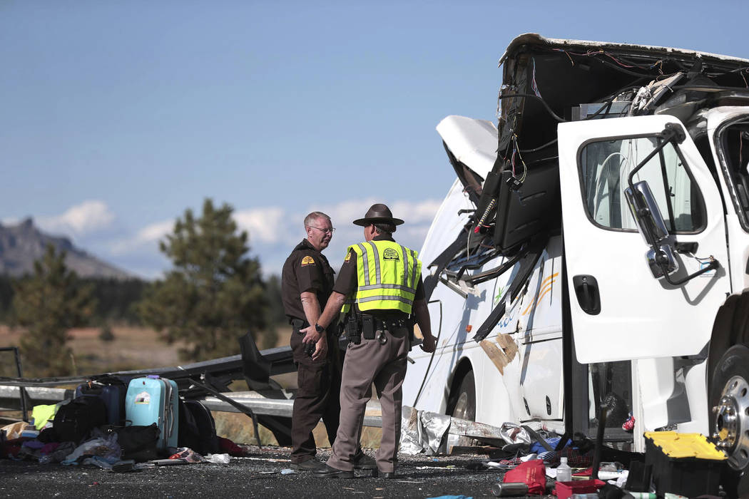 Two Utah Highway patrolmen continue to work the scene where at least four people were killed in ...