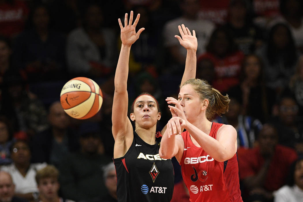 Washington Mystics center Emma Meesseman, right, passes the ball against Las Vegas Aces forward ...