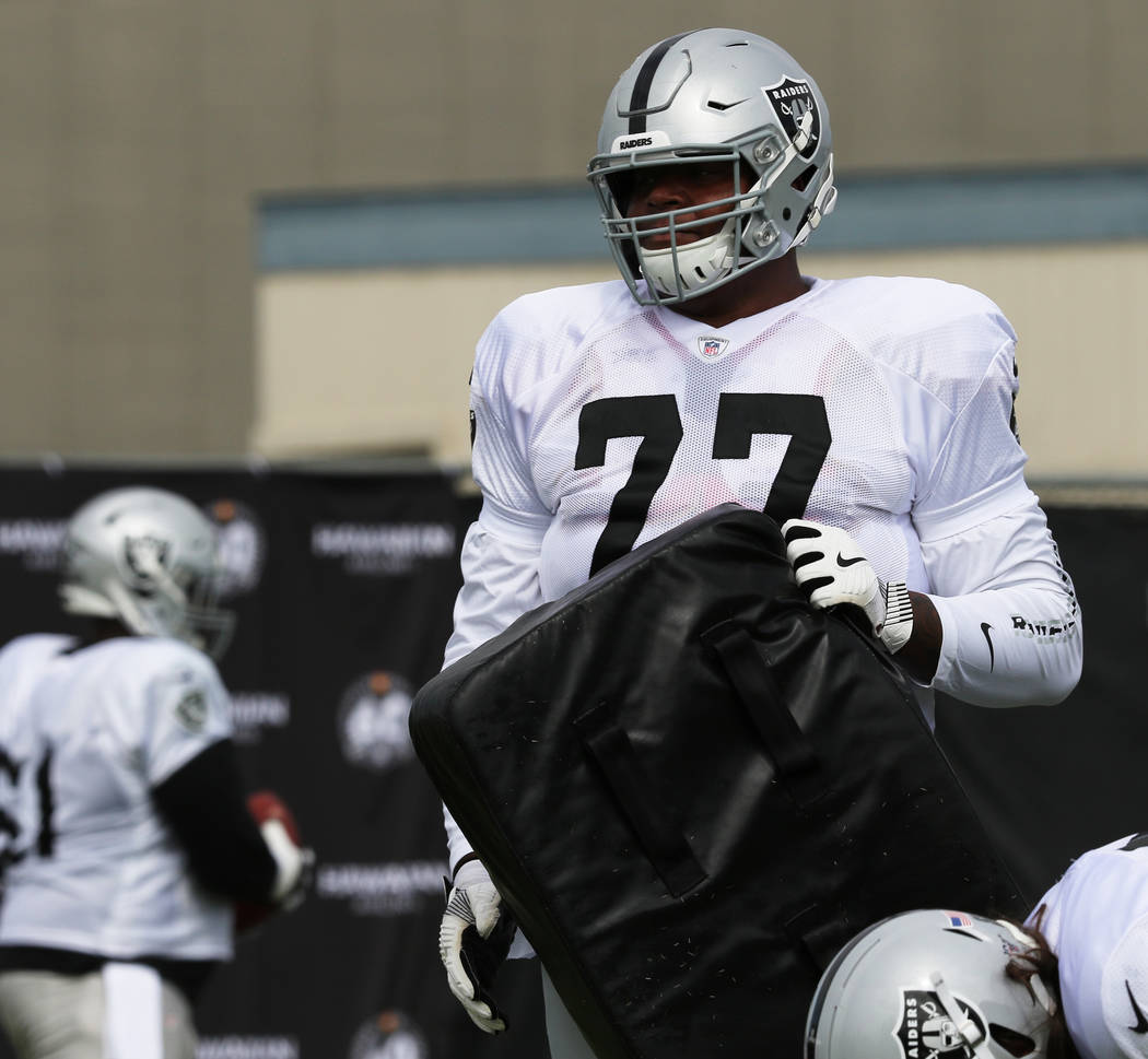 Oakland Raiders offensive tackle Trent Brown (77) holds on to a pad during the NFL team's train ...