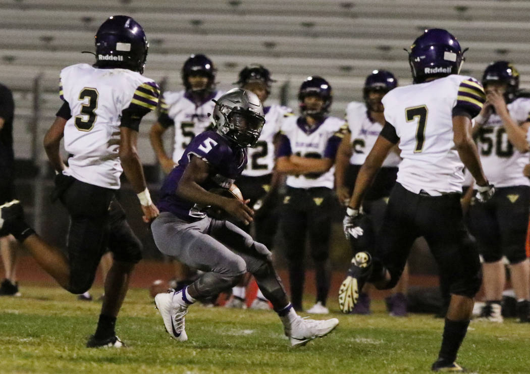 Silverado High's running back Jacob Mendez, center, surrounded by Durango High defense during t ...