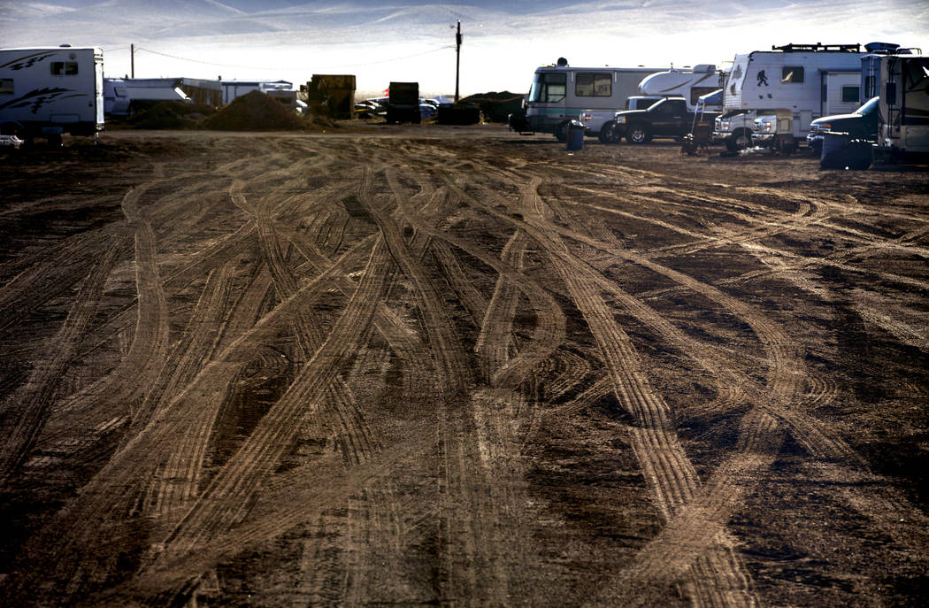 Morning falls on vehicle tracks in the RV parking area during the Alienstock festival on Saturd ...
