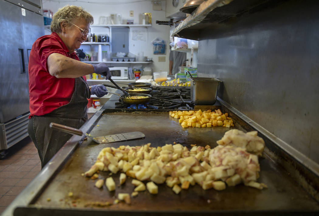 Pat Travis of the Little A'Le'Inn cooks breakfast for customers as usual with the help of famil ...