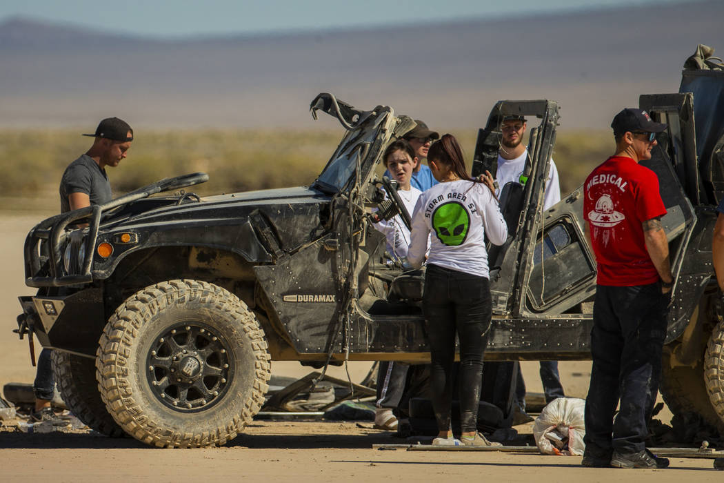 Festivalgoers connected to the scene of a vehicle rollover are assisted by emergency and medica ...