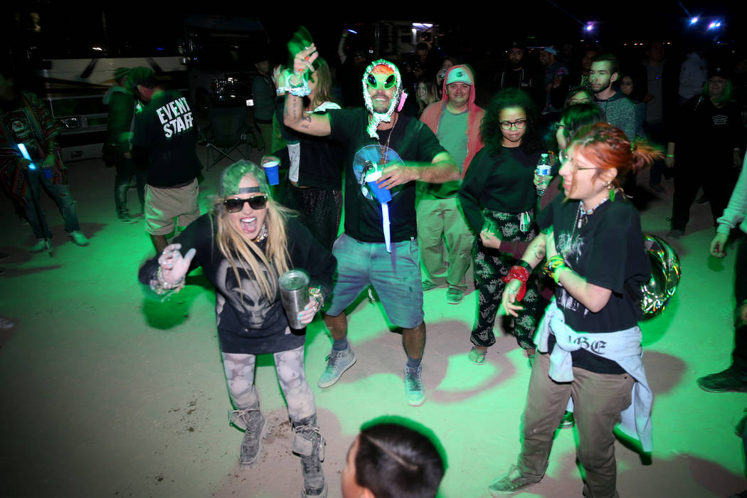 People dance during a performance by Grammy-nominated DJ Paul Oakenfold during the Alien Baseca ...