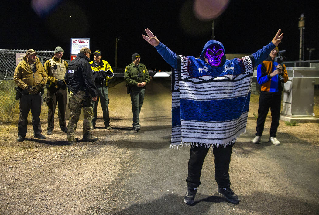 A costumed man stands near security personnel outside the back gate of Area 51 in homage to the ...