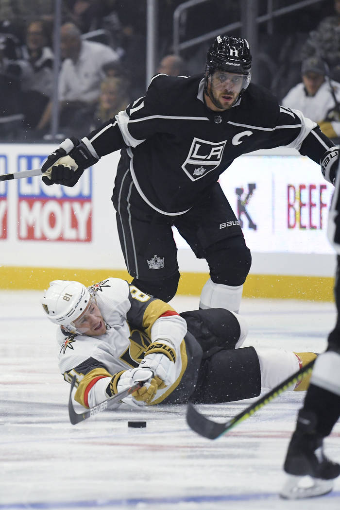 Vegas Golden Knights center Jonathan Marchessault, below, falls as he passes the puck while und ...