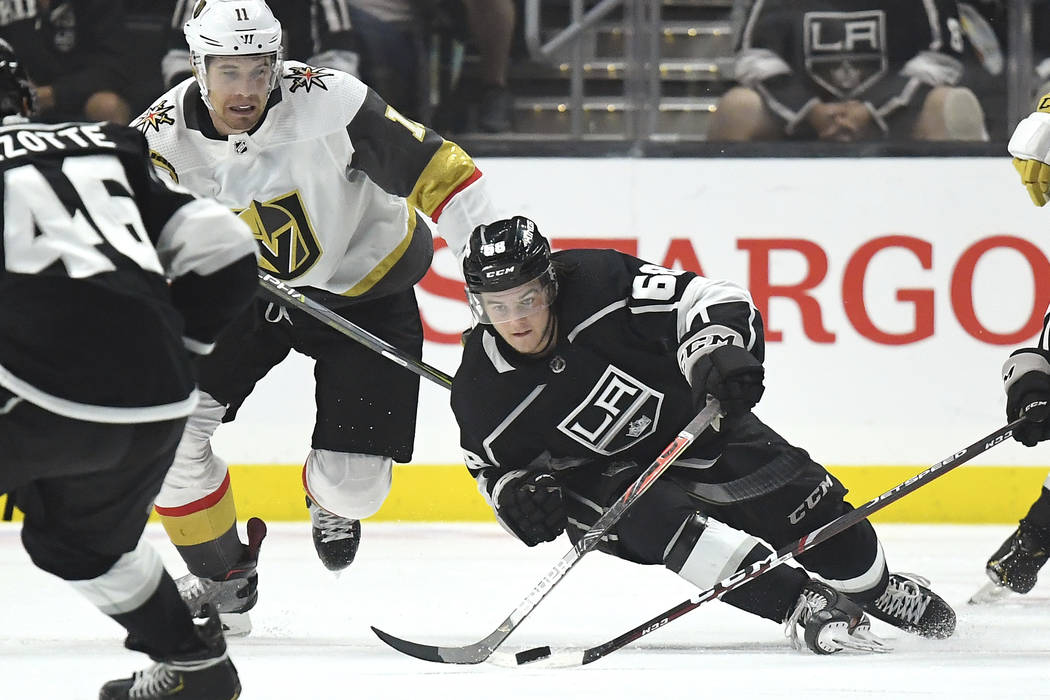 Los Angeles Kings left wing Samuel Fagemo, right, passes the puck as he falls, while Vegas Gold ...