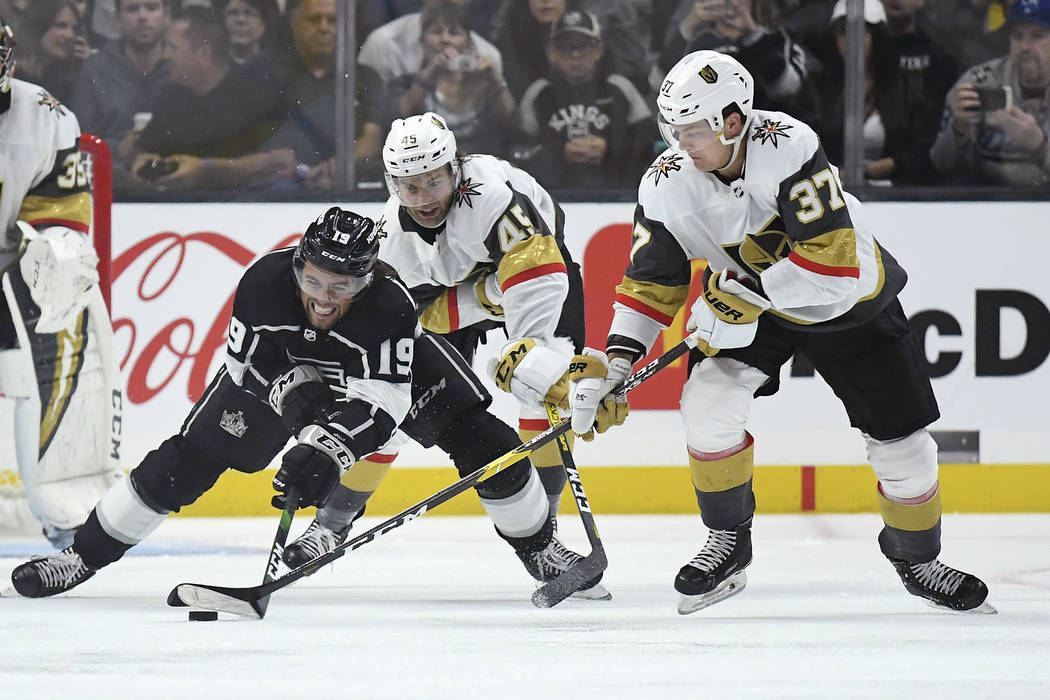 Los Angeles Kings left wing Alex Iafallo, left, tries to pass the puck while under pressure fro ...