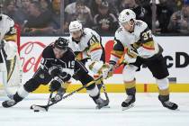 Los Angeles Kings left wing Alex Iafallo, left, tries to pass the puck while under pressure fro ...