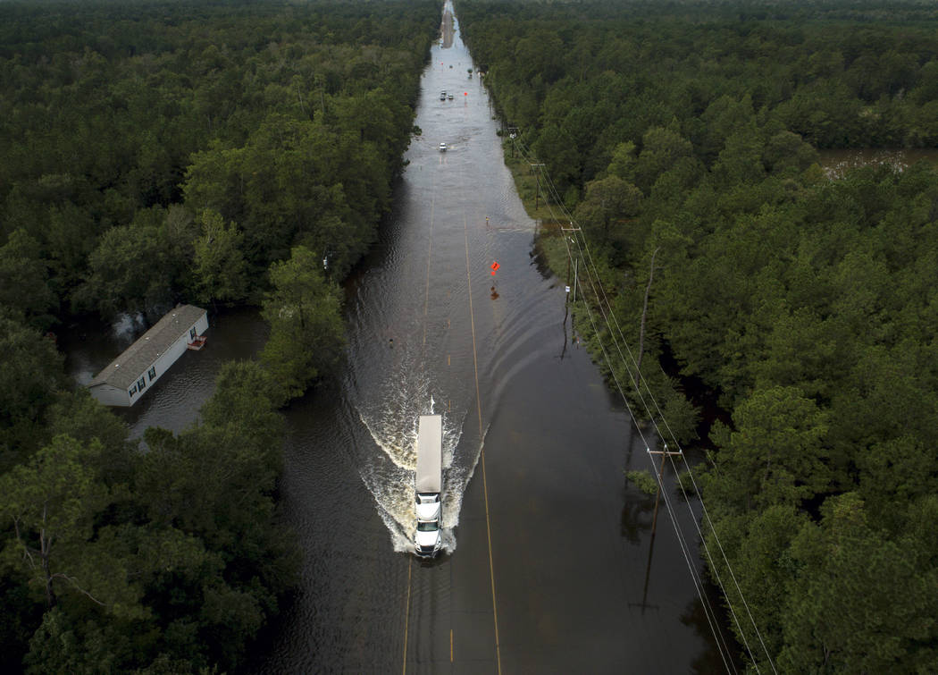 A truck drives through a flooded highway as flooding from the remnants of Tropical Storm Imelda ...