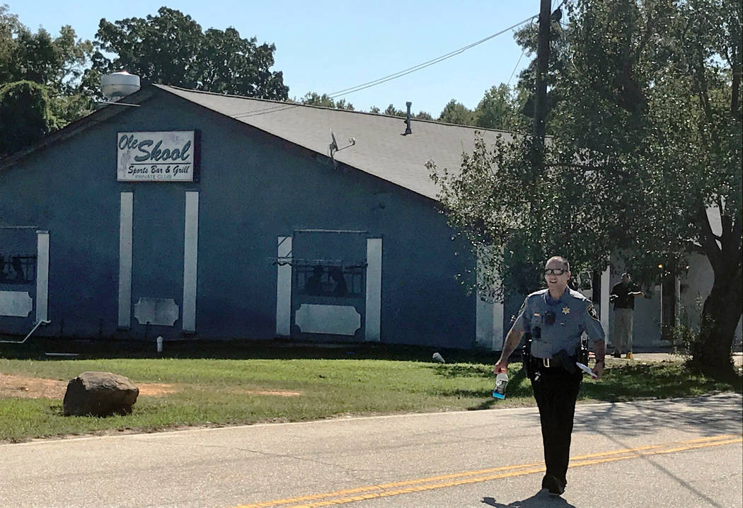 A Lancaster County Sheriff's deputy walks around the Old Skool Sports Bar and Grill, the scene ...