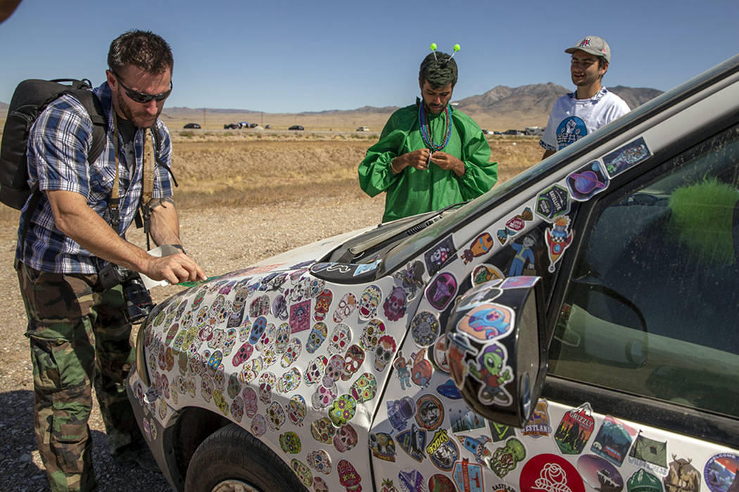 Festivalgoers add stickers to a car parked on the frontage road during the Alienstock festival ...