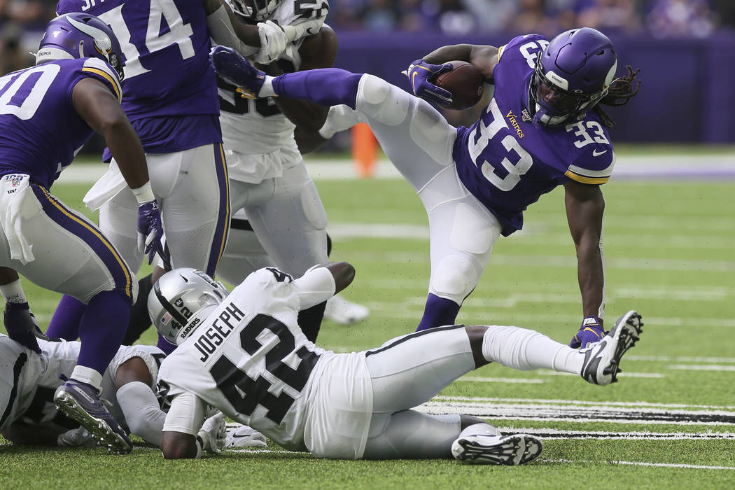 Minnesota Vikings running back Dalvin Cook (33) is upended by Oakland Raiders free safety Karl ...