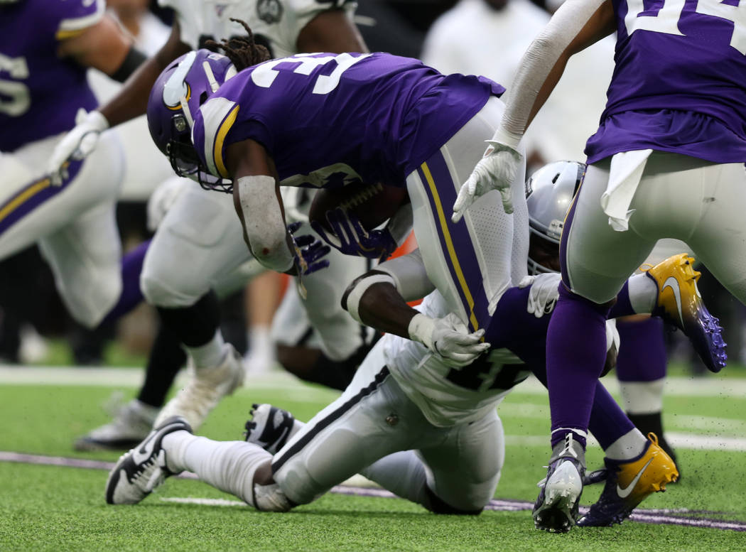 Minnesota Vikings running back Dalvin Cook (33) is tackled by Oakland Raiders free safety Karl ...