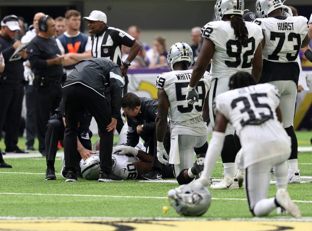 Oakland Raiders defensive tackle Johnathan Hankins (90) is helped on the field by trainers afte ...