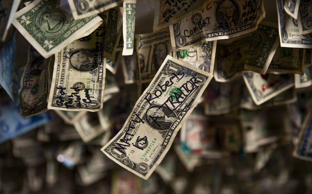 A dollar bill written with "Matty Roberts is a Traitor" hangs amongst many other from ...