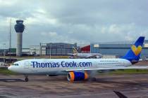 A Thomas Cook plane taxis on the runway at terminal one of Manchester Airport, England, in 2019 ...
