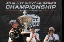 Josef Newgarden, left, kisses the trophy after winning the championship after an IndyCar auto r ...