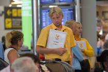 Thomas Cook staff speak with British passengers at Palma de Mallorca airport on Monday Sept. 23 ...