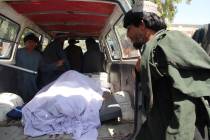 Afghans transport the body of a woman who was killed during a raid conducted by Afghan special ...