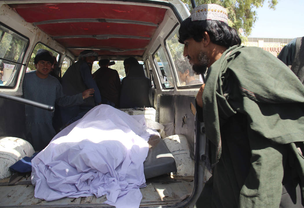 Afghans transport the body of a woman who was killed during a raid conducted by Afghan special ...