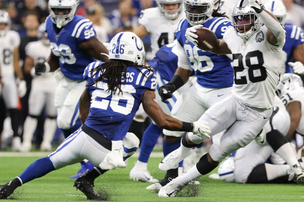 Oakland Raiders running back Josh Jacobs (28) runs past Indianapolis Colts strong safety Clayto ...
