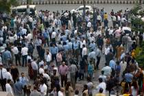 People stand outside their offices after an earthquake is felt in Islamabad, Pakistan, Tuesday, ...