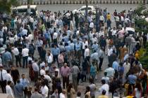 People stand outside their offices after an earthquake is felt in Islamabad, Pakistan, Tuesday, ...