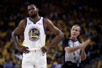 Golden State Warriors' Kevin Durant, left, walks away from referee Ken Mauer during the first h ...