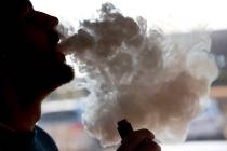 FILE - In this Friday, Jan. 18, 2019 file photo, a man exhales a puff of smoke from a vape pipe ...