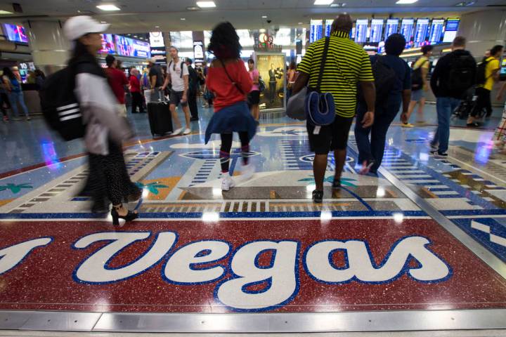 Passengers walk around the baggage claim area at McCarran International Airport ahead of the La ...